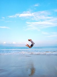 Side view of person paragliding on beach