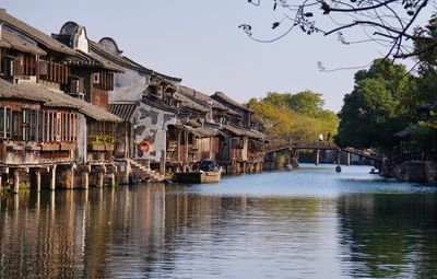 River by houses against clear sky