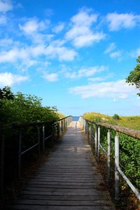 View of footbridge against cloudy sky