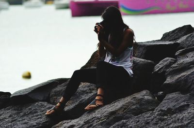 Woman sitting on stone