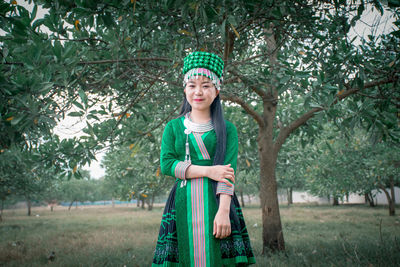 Portrait of girl standing on tree