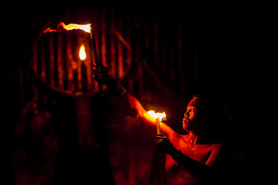 Close-up of lit candle in dark room