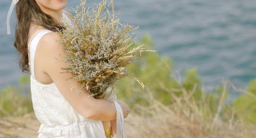 Midsection of woman standing by plants