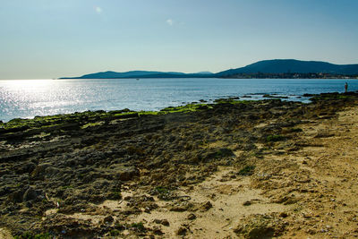 View of calm beach against blue sky