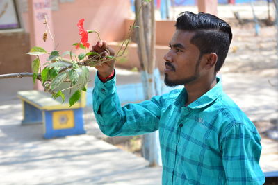 Young man holding flowering plant