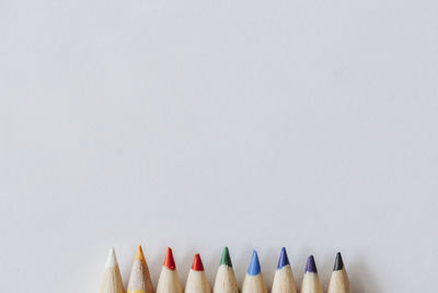 Rainbow of coloring pencil tips on plain white background
