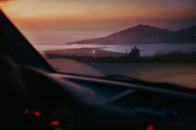 Scenic view of sunset seen through car windshield