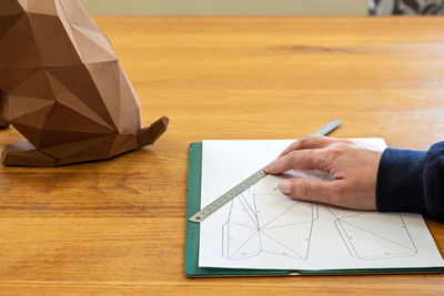 High angle view of man holding paper on table