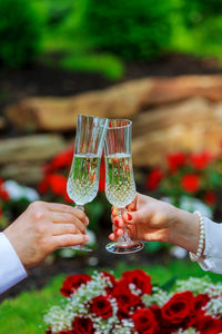 Cropped hands of bride and bridegroom toasting champagne flutes