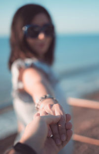 Portrait of woman with hands against sea against sky