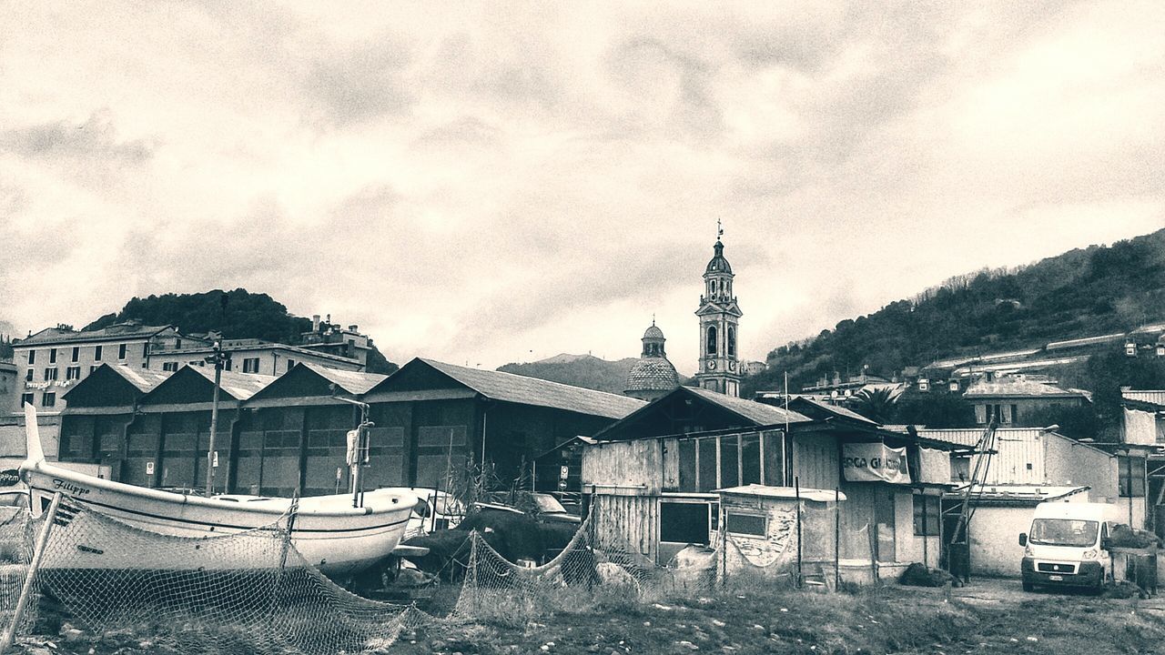 BOATS MOORED BY BUILDINGS AGAINST SKY