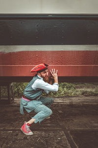 Side view of girl standing with umbrella