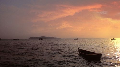 Boat sailing in sea at sunset