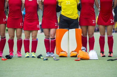 Low section of female sports players standing on playing field