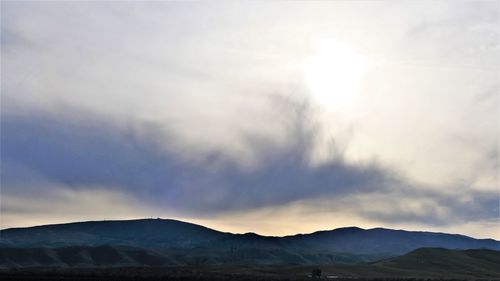 Scenic view of silhouette mountains against sky at sunset