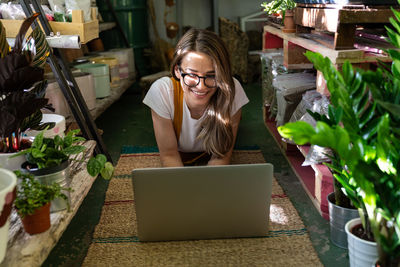 Young woman using laptop on floor