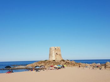 Castle at beach against clear sky