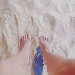 Low section of woman on sandy beach