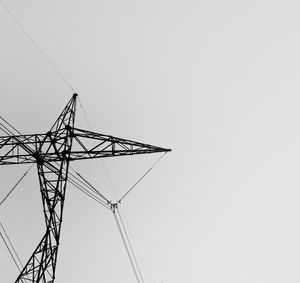 Low angle view of electricity pylon against clear sky