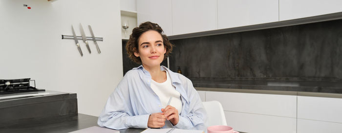 Portrait of young woman standing in office