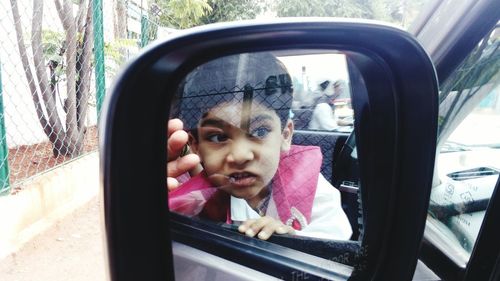 Close-up of girl looking through window