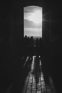 Silhouette people in corridor against sky