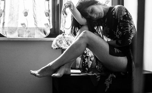 Young woman sitting on seat at home