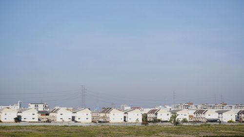 Houses on field against sky