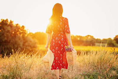 Sun and womens health, vitamin d and summer sun. back view woman on sunset in nature background