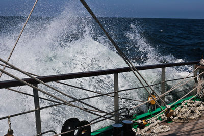 Low section of people on sea against sky