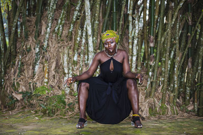 African tribal woman sitting in the jungle with face painting and headdress
