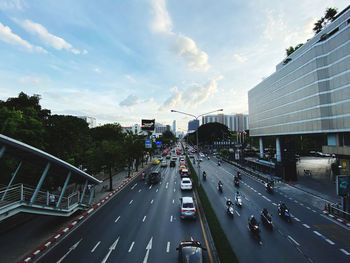 Vehicles on road in city against sky