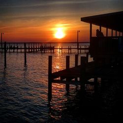 Pier on sea at sunset