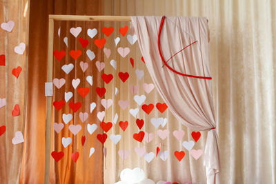 Valentines day background with paper hearts. the red and white heart shapes on wooden arch 