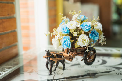 Close-up of roses in small cart on clock