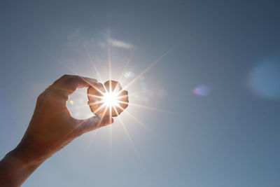 Sunlight streaming through hand against bright sun
