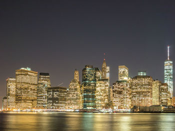 Illuminated buildings in city against sky at night