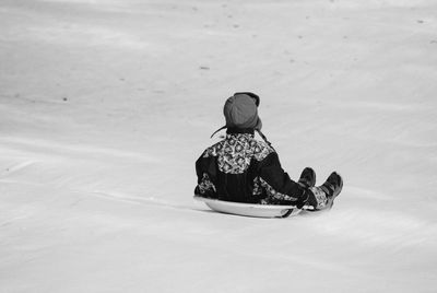 Rear view of boy ice-skating on snow