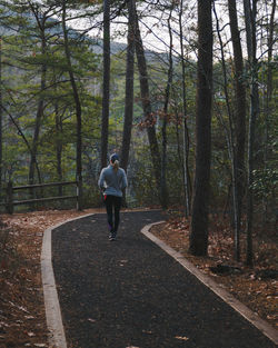 Rear view of woman jogging amidst trees