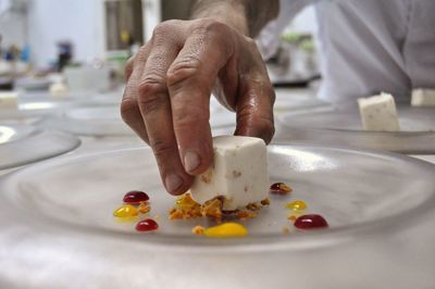 Close-up of man preparing food in plate