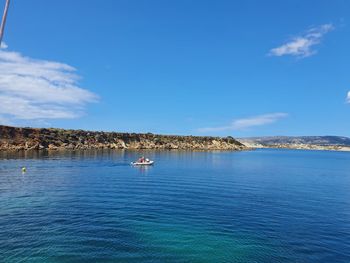 Sailboats in sea against blue sky
