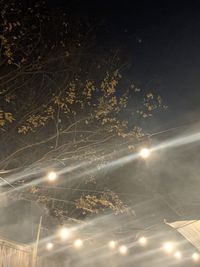 Low angle view of illuminated street lights against sky at night