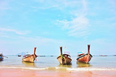 Boats moored on sea against sky