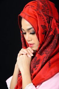 Midsection of young woman against red background
