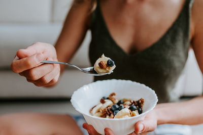 Midsection of woman holding ice cream in bowl