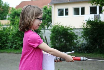 Side view of girl holding fire hose