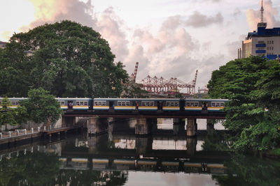 Bridge over river in city against sky