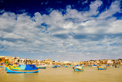 Boats moored on beach against sky