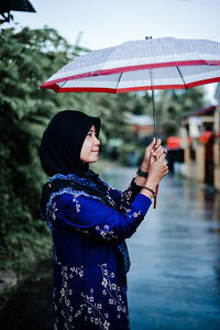 Midsection of woman holding umbrella