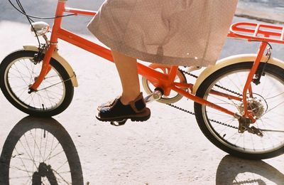 Low section of woman riding bicycle